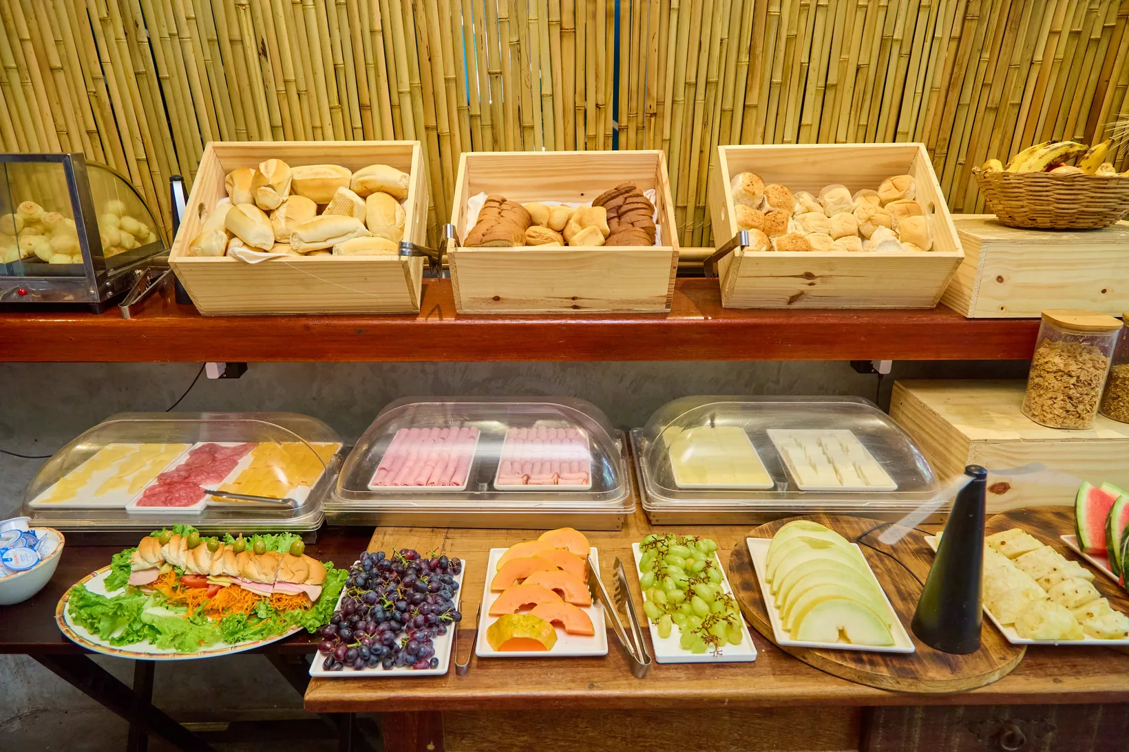Buffet de café da manhã com pães, frios e frutas em Niterói